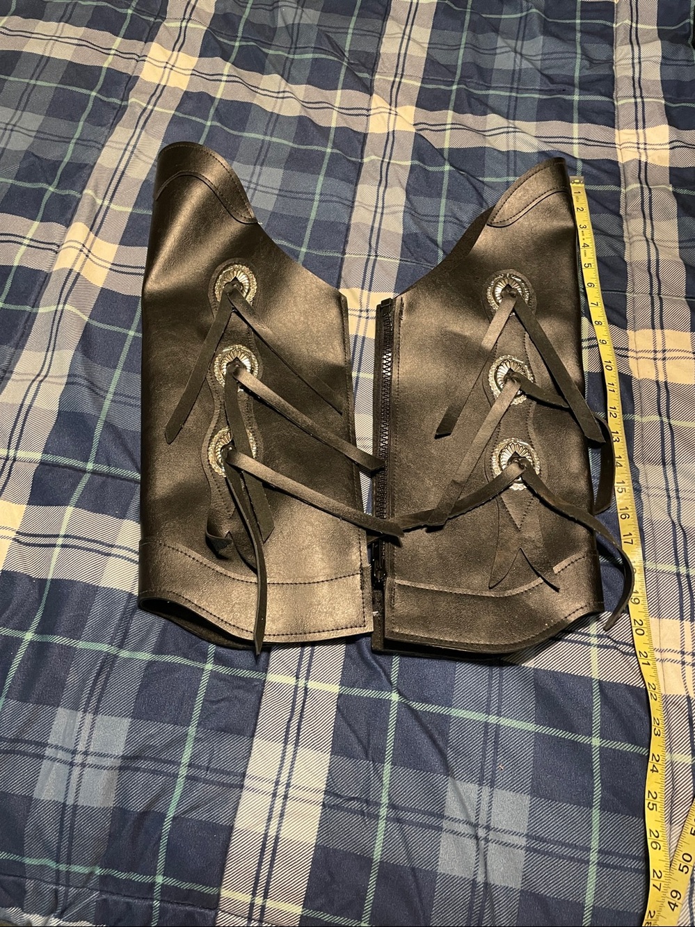 These black leather half chaps feature decorative silver conchos and lace-up det